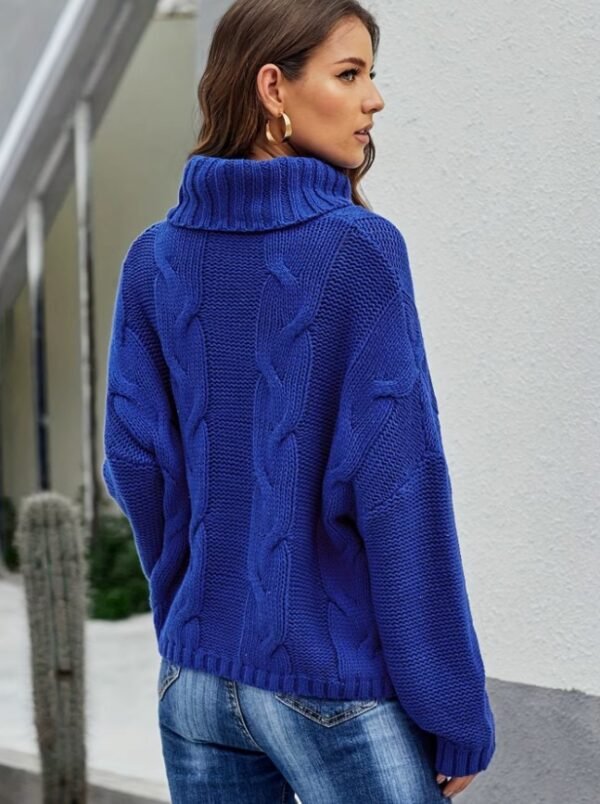 woman with brown hair turned to her back wearing navy blue colorful sweater and jeans