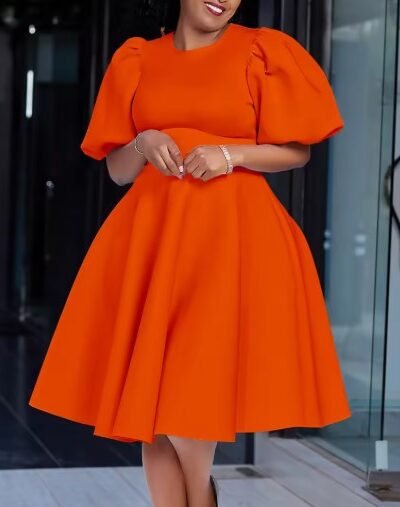 woman wearing orange dress, glass door behind her