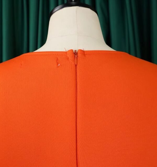 zipper of orange dress on a mannequin