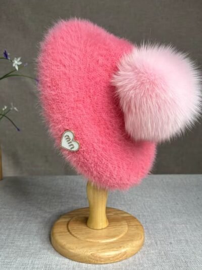 pink colorful beret with a pompom on the wooden pillar, grey table in the background