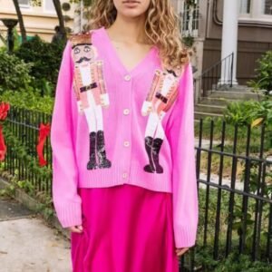 woman wearing pink colorful nut cracker cardigan and pink skirt, the garden in the background