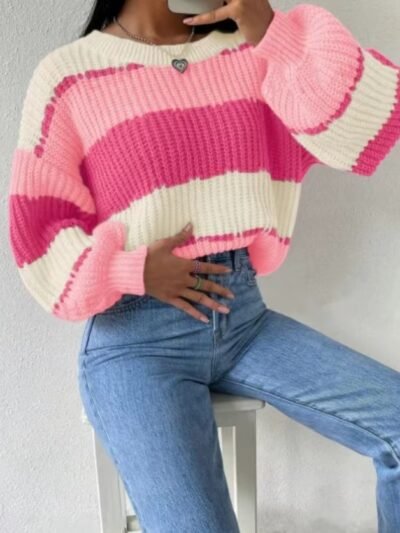 woman sitting on a white chair and wearing pink colorful sweater, jeans and a silver necklace
