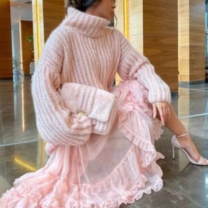 woman wearing pink colorful turtleneck sweater, pink tulle skirt, white heels and holding a pink purse