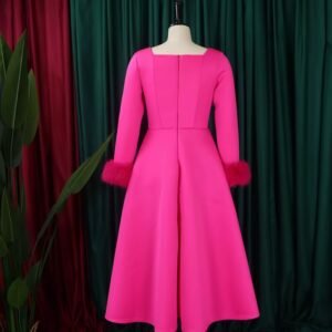 back side of pink long-sleeved colorful dress, green and red curtains in the background