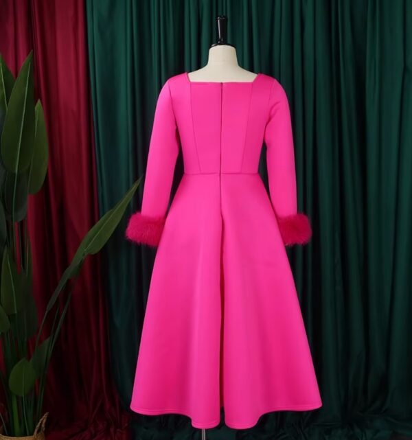 back side of pink long-sleeved colorful dress, green and red curtains in the background