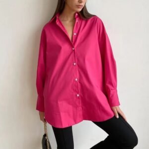 woman wearing pink oversized colorful blouse and black pants