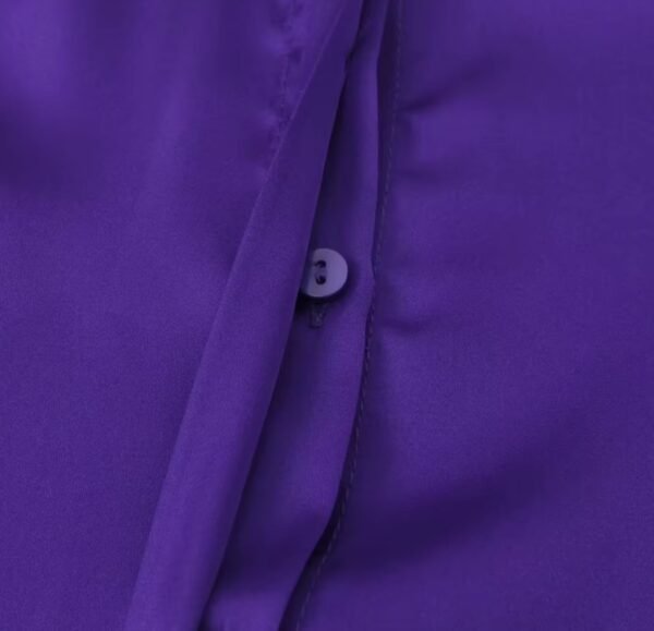 the button of the purple blouse