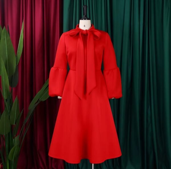 red colorful dress with a bow, green and red curtains in the background