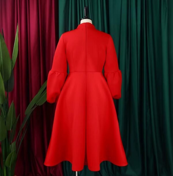 backside of red colorful dress with a bow, green and red curtains in the background