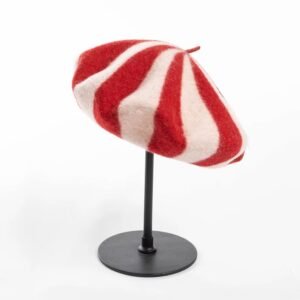 sideview of red colorful beret on a black pillar, white background