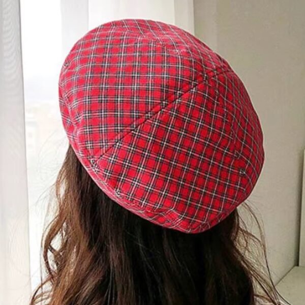 woman turned to her back wearing red plaid colorful beret