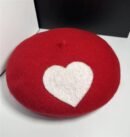 romantic colorful beret on the white table, a black box next to it