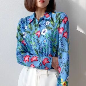 woman wearing silk colorful blouse and white jeans