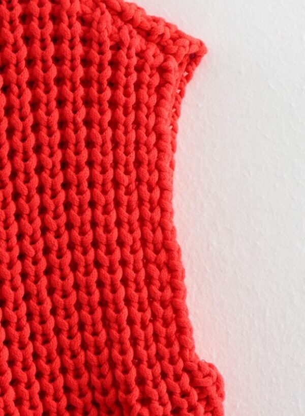 shoulder part of red sleeveless cardigan