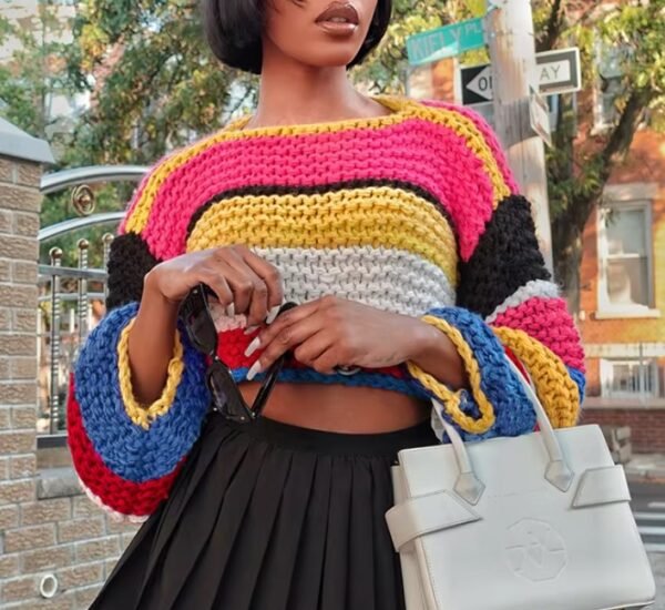 woman wearing stylish colorful sweater, black skirt and holding a white bag