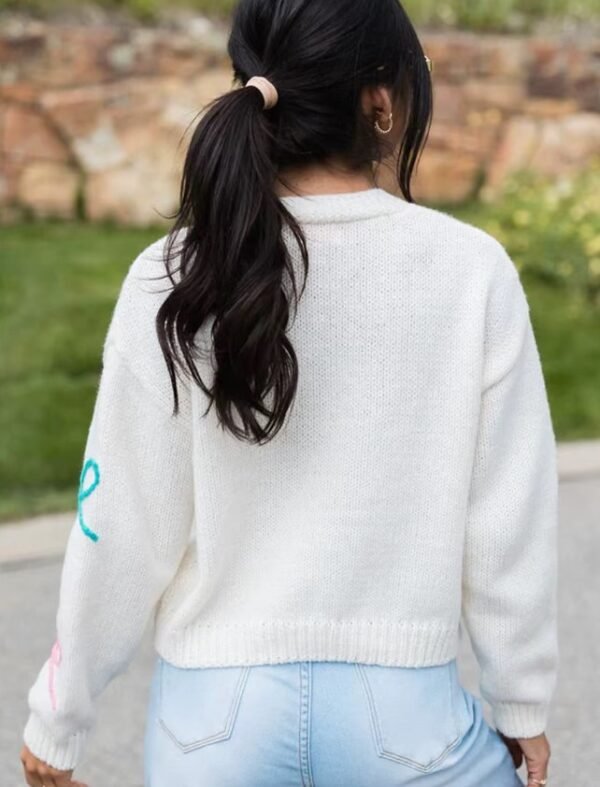 woman with black hair turned to her back wearing sweet colorful cardigan and jeans