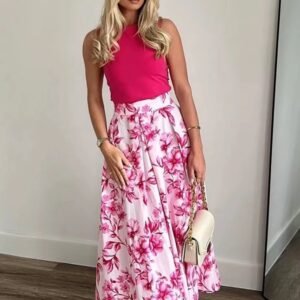 blonde woman wearing Japanese colorful skirt and a pink top, white wall behind her