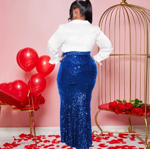 woman wearing blue colorful party skirt and a white button shirt turned to her back, red balloons and rose petals next to her