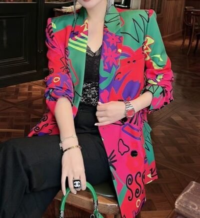 woman wearing colorful blazer for women and black pants, brown room in the backgorund