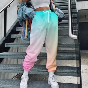 woman wearing colorful cargo pants, white top and white sneakers, grey stairs behind her