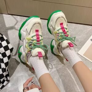 woman wearing colorful color blocking sneakers and white socks, white floor under her