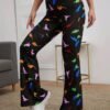 woman turned to her side wearing colorful dinosaur pants and white sneakers