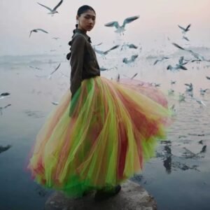 woman wearing colorful fairy skirt and black jacket, birds flying around her