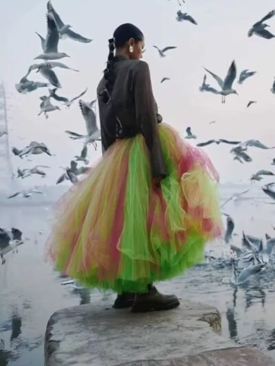 woman turned to her back wearing colorful fairy skirt and black leather jacket, birds flying around her
