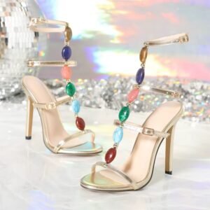 front and side view of colorful gems sandals on white floor, shiny disco ball in the background