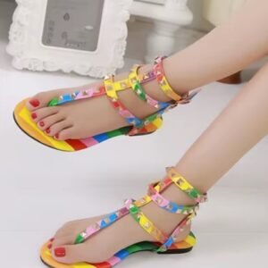 woman wearing colorful gladiator sandals, white room in the background