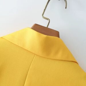 back side of yellow collar of colorful gradient blazer on a hanger