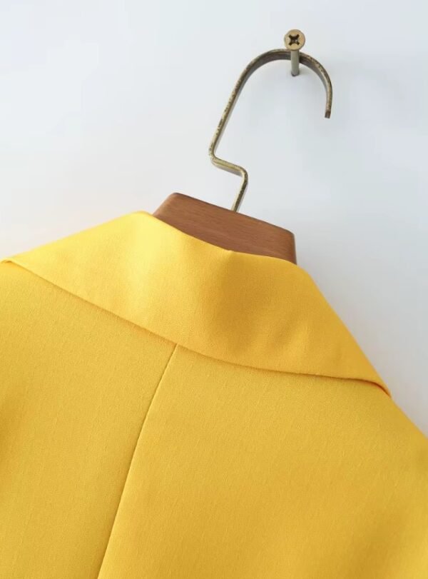 back side of yellow collar of colorful gradient blazer on a hanger