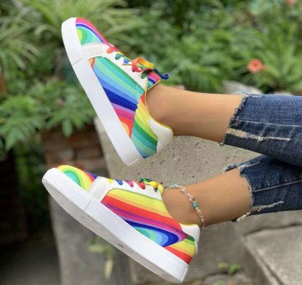 woman wearing colorful lace up sneakers exposing their side view, grass in the background