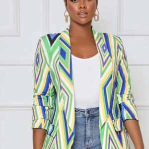 woman with short black hair wearing colorful office blazer, white top and jeans