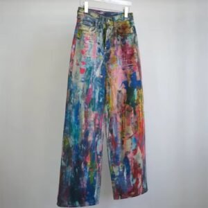 side view of colorful painted pants hanging on the grey background