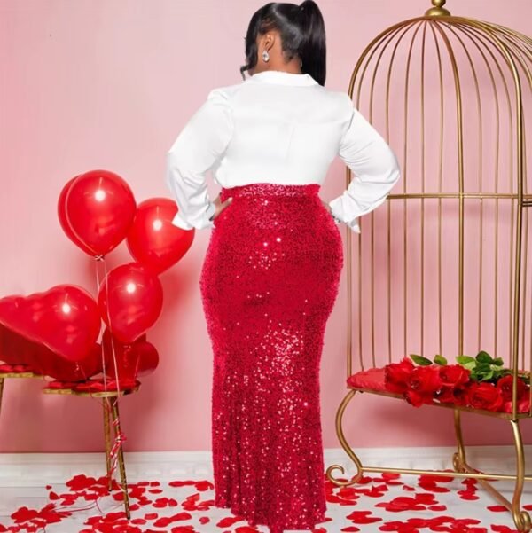 woman wearing red colorful party skirt and a white button shirt turned to her back, red balloons and rose petals next to her