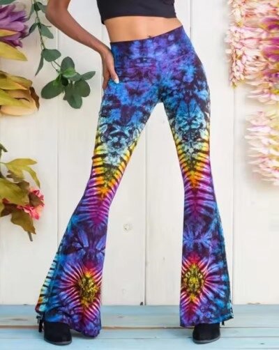 woman wearing colorful pattern pants, the wall with flowers in the background