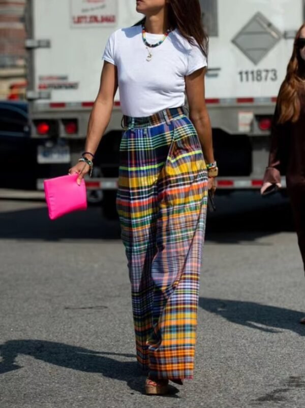 woman wearing colorful plaid pants and white T-shirt, she is holding a hot pink purse