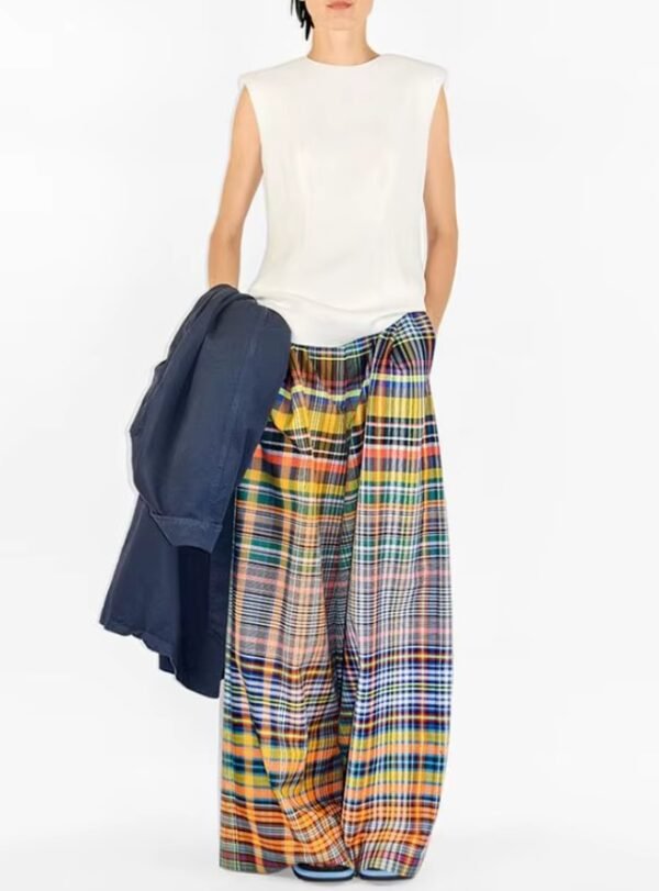 woman wearing colorful plaid pants and white top, white background