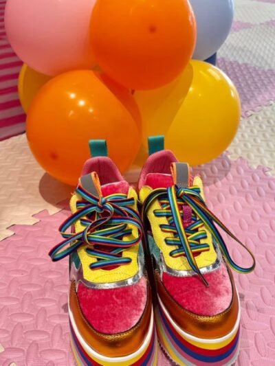 front view of colorful platform sneakers, colorful balloons behind them