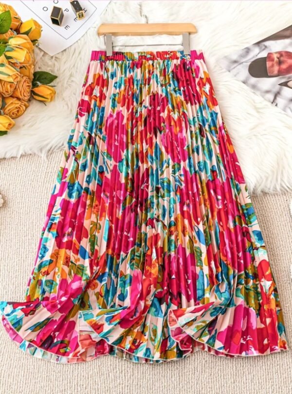 colorful pleated skirt on a carpet, yellow flowers and a newspaper next to it