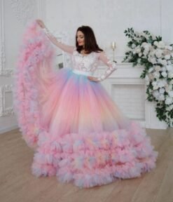 woman wearing colorful prom skirt and elegant white top, white room and flowers behind her