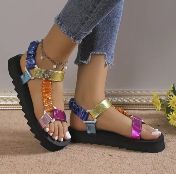 woman wearing colorful sandals for women and jeans, grey wall in the background