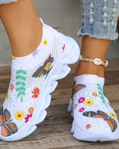 woman wearing colorful slip on sneakers, jeans and a gold ankle bracelet