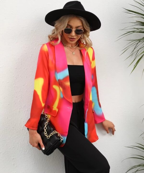 woman wearing colorful tie-dye blazer, black top, black pants and black hat, she is carrying a black purse