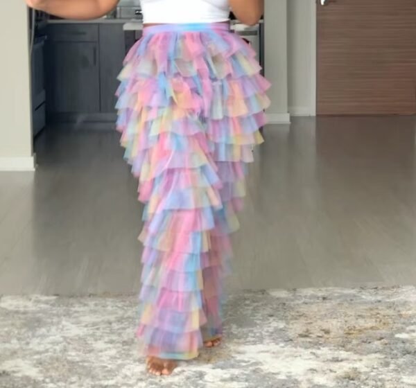 woman wearing colorful tulle pants, grey room in the backgorund