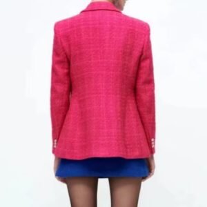 woman turned to her back wearing pink colorful tweed blazer and blue tweed short, white background