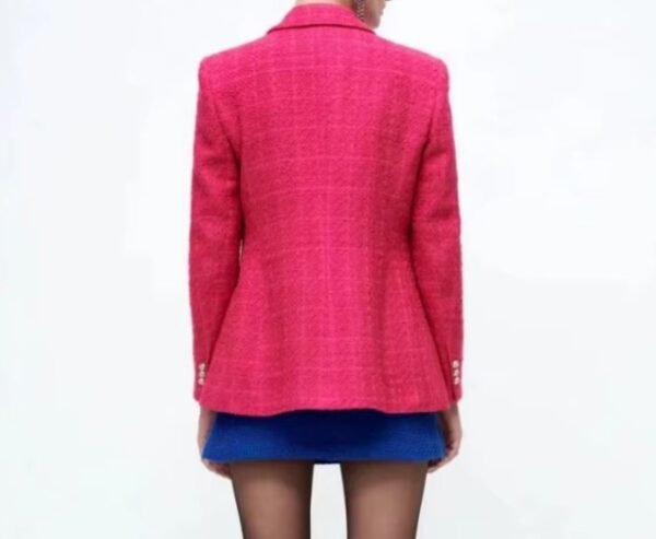 woman turned to her back wearing pink colorful tweed blazer and blue tweed short, white background