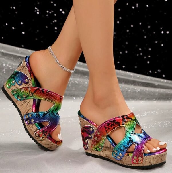 side view of colorful wedge sandals on feet, grey and black background