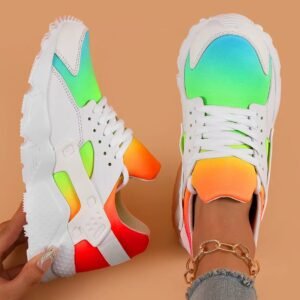 colorful womens sneakers on one feet, orange background